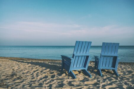 Two beach chairs on a sandy shore