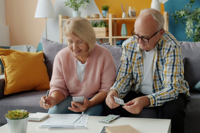 Retired couple filling out forms and counting money